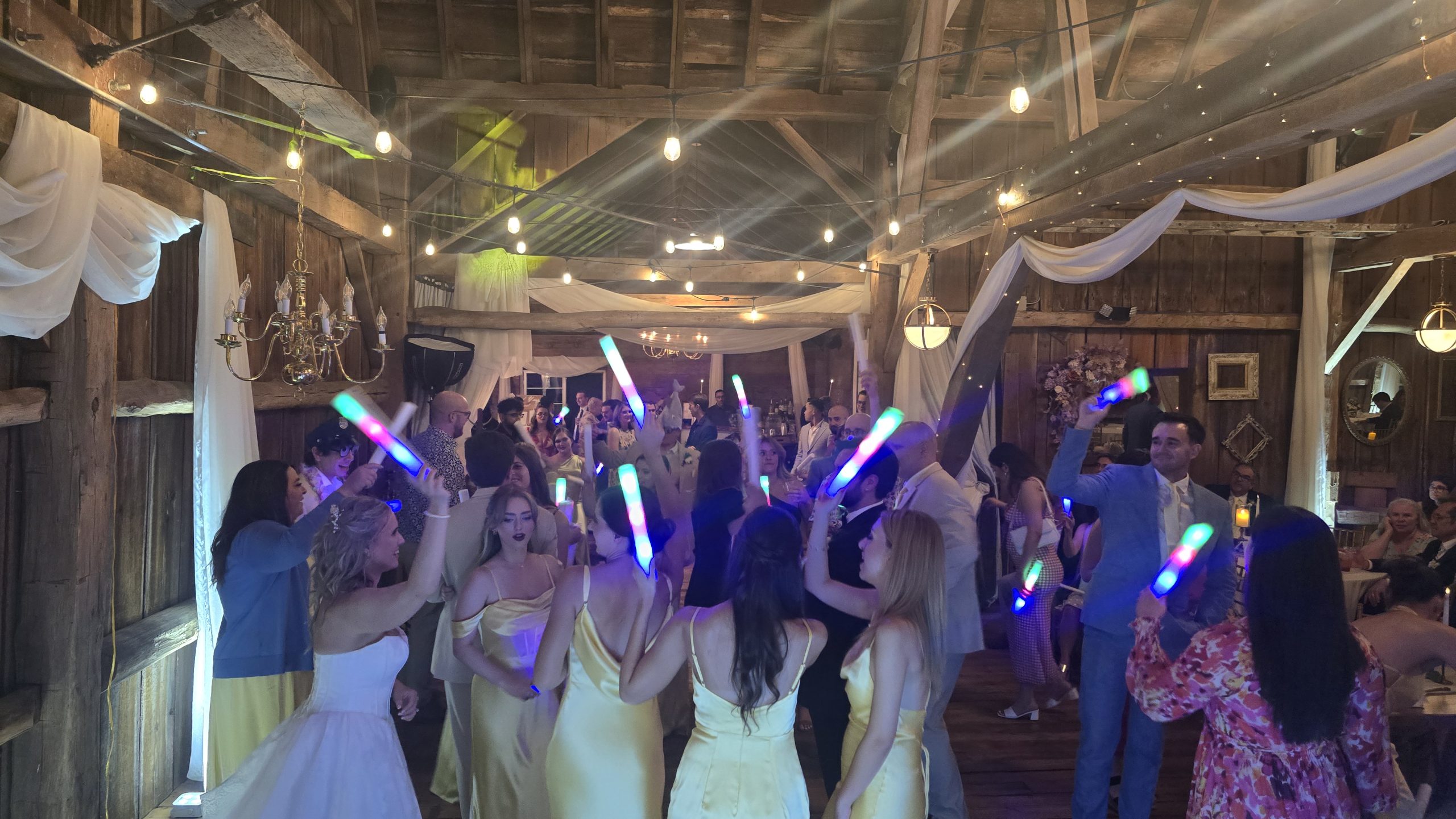 Wedding guests celebrating under colorful 1021 Events DJ lighting