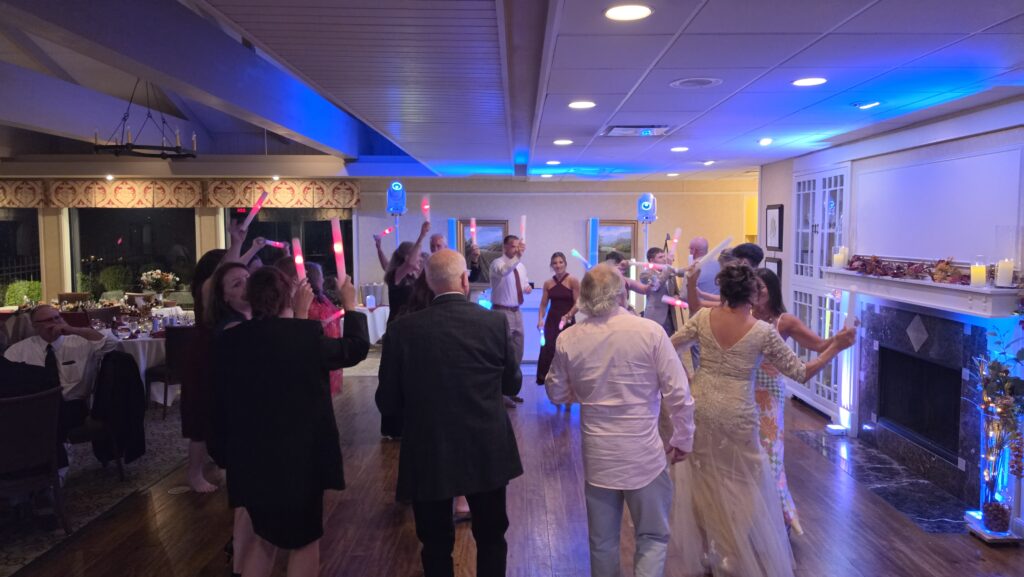 Guests dancing under blue reception lighting at Rene and Ken’s Kenosha Country Club wedding.